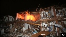 A fire still burns in a apartment complex destroyed near a fertilizer plant that exploded earlier in West, Texas, in this photo made early Thursday morning, April 18, 2013.