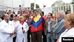 Venezuela's President-elect Nicolas Maduro (C) speaks during a visit to the Center of Integral Medical Diagnosis (CDI) of the Barrio Adentro health programe in Caracas, in this picture provided by Miraflores Palace, April 16, 2013. 