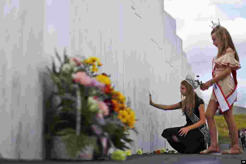 Mackenzie, right, and Madison Miller from Avonmore, Pa., visit the Wall of Names at the Flight 93 National Memorial in Shanksville, Pa., Thursday, Sept. 10, 2020, as the nation prepares to mark the 19th anniversary of the Sept. 11, 2001, attacks. The Wall of Names honors the 40 people killed in the crash of Flight 93. (AP Photo/Gene J. Puskar)