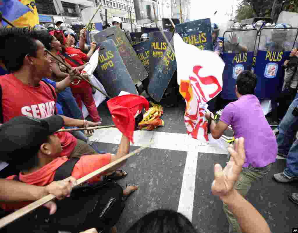 Para demonstran di Manila, Filipina, bentrok dengan polisi saat hendak menuju Kedutaan Besar Amerika Serikat untuk memperingati Hari Perempuan Internasional. Ribuan warga turun ke jalan untuk menyerukan penghentian kekerasan terhadap perempuan dan anak-anak. (AP/Bullit Marquez)