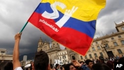 FILE - A supporter of the peace deal between the Colombian government and rebels of the Revolutionary Armed Forces of Colombia waves a flag during a rally in front of Congress, in Bogota, Colombia, Oct. 3, 2016. After Colombians rejected the deal, both sides are returning to talks in Cuba.