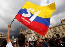 FILE -- A supporter of the peace deal between the Colombian government and rebels of the Revolutionary Armed Forces of Colombia waves a flag during a rally in front of Congress, in Bogota, Colombia, Oct. 3, 2016.