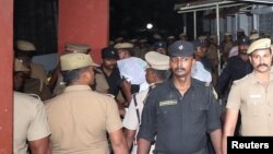 Police escort one of the men (face covered) accused of raping a 12-year girl inside the high court premises in Chennai, India, July 17, 2018. 