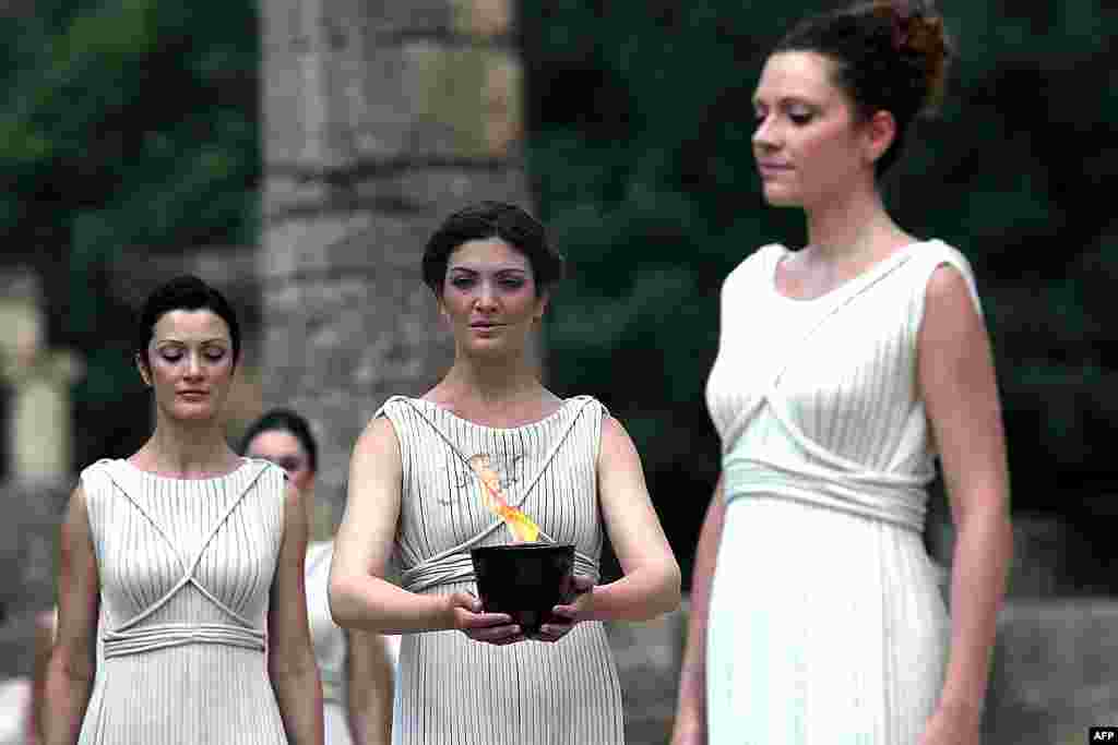 A pot with the Olympic flame is held during the lighting of the flame ceremony at the site of ancient Olympia, Greece, May 10, 2012. (AP)