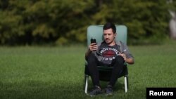 Therapist Pedro Schargorodsky works with a patient by WhatsApp video call, at his home in Buenos Aires, Argentina April 7, 2020. (REUTERS/Agustin Marcarian)