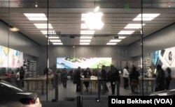 Customers check new Apple smartphones and watches at an Apple store in Woodbridge, northern Virginia, March 11, 2016. (photo: Diaa Bekheet/VOA)