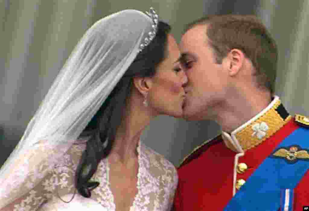 Britain's Prince William, right, kisses his wife, Kate, the Dutchess of Cambridge, from the balcony of Buckingham Palace after the Royal Wedding in London on Friday, April 29, 2011 (AP Photo/APTN)