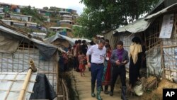 International Committee of the Red Cross President Peter Maurer, foreground and left, visits a Rohingya refugee camp in Cox's Bazar, Bangladesh, July 1, 2018.