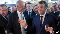 French President Emmanuel Macron, right, samples local produce and wine as he tours the exhibition hall on the opening day of the G7 summit, in Anglet, France, Aug.24, 2019. 