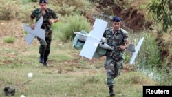 Lebanese soldiers carry parts of an Israeli MK drone that fell in South Lebanon's Marjeyoun countryside near the border with Israel. Israeli media said the IDF confirmed the drone was from Israel.