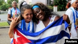 쿠바 정부가 미국과 약속 이행으로 석방한 반체제 인사 53중 2명이 11일 하바나에서 국기를 들고 기뻐하고 있다.