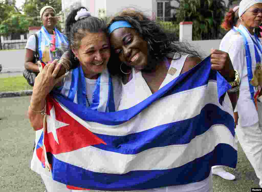 Recently released dissidents Aide Gallardo (left) and Sonia Garro hold the Cuban national flag during a march. Cuba has released all 53 prisoners it had promised to free, senior U.S. officials said, Havana, Cuba, Jan. 11, 2015.