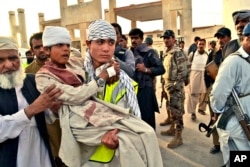A Pakistani boy, who was injured by gunmen, is carried to a vehicle outside a hospital in Quetta, Pakistan, June 15, 2013.