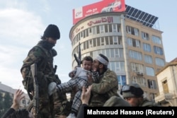 Pemberontak mencium seorang anak di Homs usai kekuasaan Assad dinyatakan berakhir, 8 Desember 2024. (Foto: Mahmoud Hasano/Reuters)