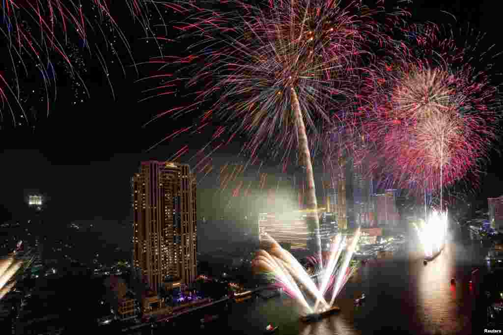 Fireworks explode over Chao Phraya River during the New Year&#39;s celebrations in Bangkok, Thailand.