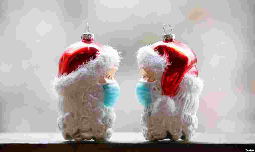 Christmas baubles shaped as Santa Clauses wearing protective masks are pictured amid the COVID-19 pandemic in Eichenau, Germany.