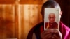 FILE - A monk is seen holding a picture of Tibetan spiritual leader Dalai Lama.