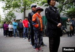 Voters wait for a polling station to open for the presidential elections in Seoul, South Korea, May 9, 2017.