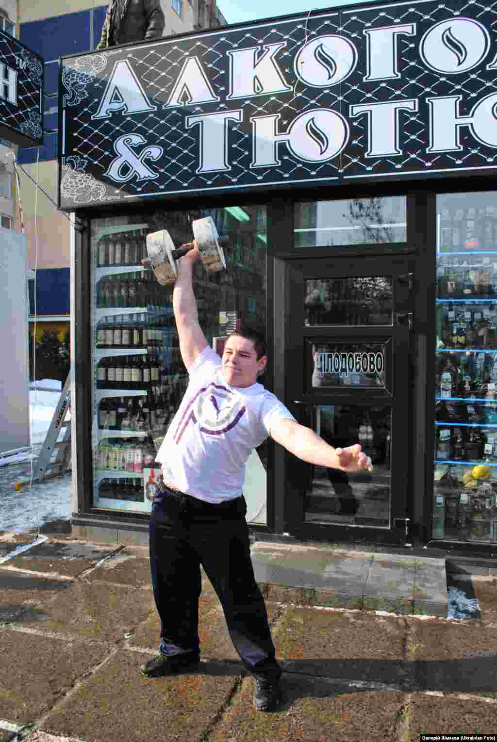 Акція &quot;Алкостоп&quot; у Львові. Активісти провели флешмоб проти незаконної реклами алкоголю. Під час флеш-мобу учасники копали мяч та піднімали гантелі безпосередньо перед кіоском з горілкою.
