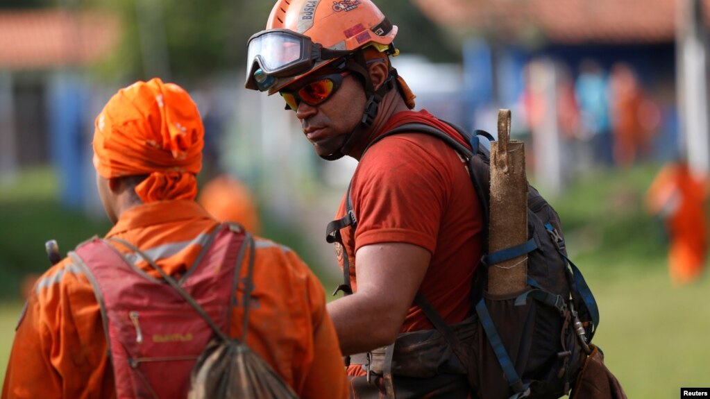 A firefighter and a rescue worker are seen after a tailings dam from Brazilian miner Vale SA burst in Brumadinho, Brazil, Jan. 27, 2019. 