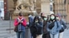 Para pengunjung mengenakan masker pelindung saat berjalan di Florence di tengah upaya pemerintah Italia memerangi wabah virus corona, Sabtu, 7 Maret 2020. 