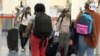 Pasajeros en el Aeropuerto Internacional de Miami caminan con mascarillas para tomar un vuelo para el día de Acción de Gracias. [Foto: Antoni Belchi, VOA]