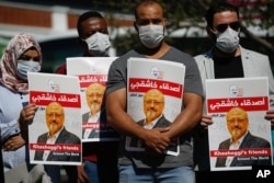 FILE - People hold posters of slain Saudi journalist Jamal Khashoggi, near the Saudi Arabia consulate in Istanbul, marking the two-year anniversary of his death, Oct. 2, 2020.