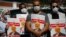People hold posters of slain Saudi journalist Jamal Khashoggi, near the Saudi Arabian Consulate in Istanbul, marking the two-year anniversary of his death, Oct. 2, 2020.