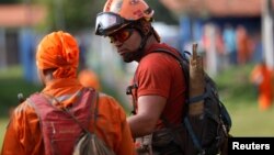 A firefighter and a rescue worker are seen after a tailings dam from Brazilian miner Vale SA burst in Brumadinho, Brazil, Jan. 27, 2019. 