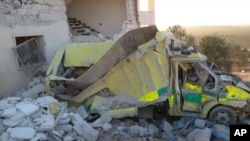 This photo provided by the Shafak Charity Organization, which has been authenticated based on its contents and other AP reporting, shows an ambulance destroyed following four consecutive airstrikes on a medical facility dedicated to women in northern Idlib province, Syria, Nov. 25, 2016.