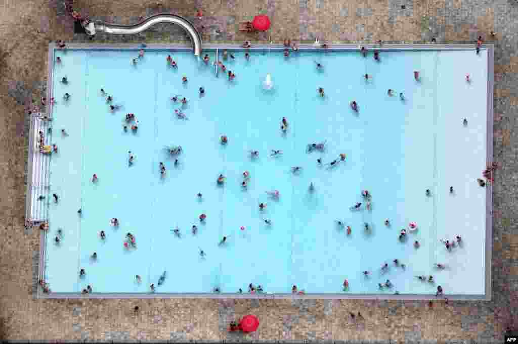 People swim at the Kiebitzberge public outdoor swimming pool on a warm summer day in Kleinmachnow, Germany.