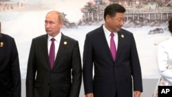 Russian President Vladimir Putin, left, and Chinese President Xi Jinping line up for a photo during the BRICS Summit in southeastern China's Fujian province, Sept. 4, 2017.