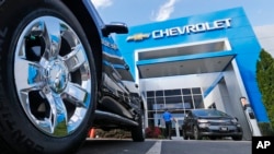 This April 26, 2017 photo shows the logo on the wheel of an SUV in front of a Chevrolet dealership in Richmond, Va. General Motors and Ford each posted strong U.S. sales in Sept. 2017, confirming predictions that the industry could rebound for the month. 