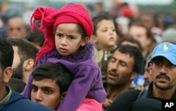 Para pengungsi menanti untuk naik bis setelah menyeberangi perbatasan Hungaria-Austria di Nickelsdorf, 70 kilometer sebelah tenggara Wina (11/9).(AP Photo/Ronald Zak)