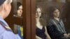 Feminist punk group Pussy Riot members, from left, Nadezhda Tolokonnikova, Maria Alekhina and Yekaterina Samutsevich sit in a glass cage at a court room in Moscow, Russia, August 8, 2012. 