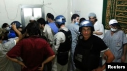 U.N. chemical weapons experts visit a hospital where wounded people affected by a suspected gas attack are being treated, in the southwestern Damascus suburb of Mouadamiya, Aug. 26, 2013. 