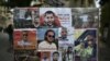Portraits de détenus algériens exposés, dont Walid Kechida -un partisan du mouvement de protestation Hirak en Algérie- devant l'ambassade d'Algérie à Paris, le 12 août 2020.