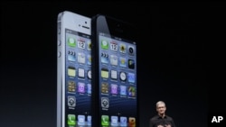 Apple CEO Tim Cook speaks in front of an image of the iPhone 5 during an Apple event in San Francisco, Sept. 12, 2012.