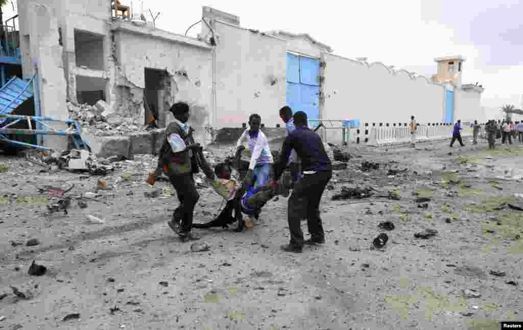 2013年6月19日，摩加迪沙一处联合国大院遭到自杀炸弹袭击后，索马里政府军士兵把一名受伤的人转移出大院。