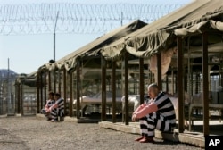 Inmates sit next to their bunks in the courtyard of Maricopa County Sheriff Joe Arpaio's jail in Phoenix, Arizona, Jan. 31, 2008.