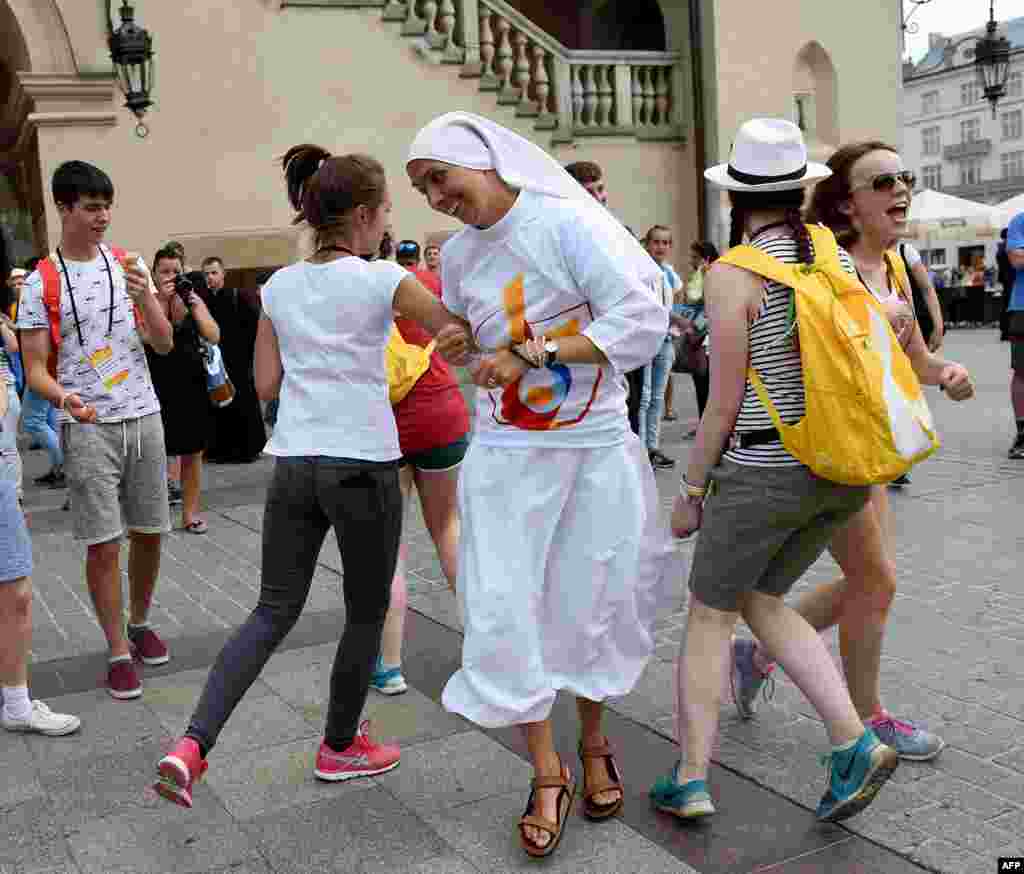 Young people from around the world dance with a nun at the market square in Krakow, Poland, ahead of the official opening of the World Youth Day, with the participation of Pope Francis.