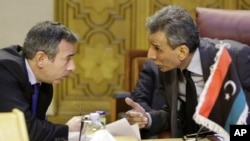 Ashour Abu-Rashed, right, Libyan representative at the Arab League, talks to his Egyptian counterpart, Tarek Adel, during an emergency meeting in Cairo to discuss the conflict in Libya, Jan. 5, 2015.