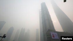An electronic screen and buildings are seen amid heavy smog at the financial district of Pudong in Shanghai, Dec. 6, 2013.