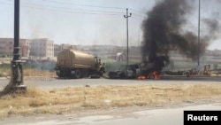 Burning vehicles belonging to Iraqi security forces are seen during clashes between security forces and al Qaida-linked Islamic State in Iraq and the Levant (ISIL) in the northern city of Mosul, June 10, 2014.