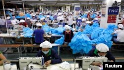 Công nhân may quần áo bảo hộ và khẩu trang ở nhà máy TNG tỉnh Thái Nguyên, 23/03/2020.