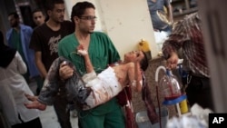 A doctor carries a severely wounded Syrian boy in the city of Aleppo.