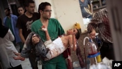 A doctor carries a severely wounded Syrian boy in the city of Aleppo. 