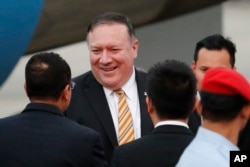 FILE - U.S. Secretary of State Michael Pompeo is greeted by local officials as he arrives at the military airport in Subang, outside of Kuala Lumpur, Malaysia, Aug. 2, 2018.