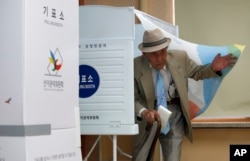 A local resident comes out of a polling booth to cast his ballot for parliamentary elections at a polling station in Seoul, South Korea, April 13, 2016.