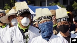 Protesters wear masks as a precaution against the MERS, Middle East Respiratory Syndrome, virus during a rally against government's labor policy in Seoul, South Korea, Sunday, June 7, 2015.